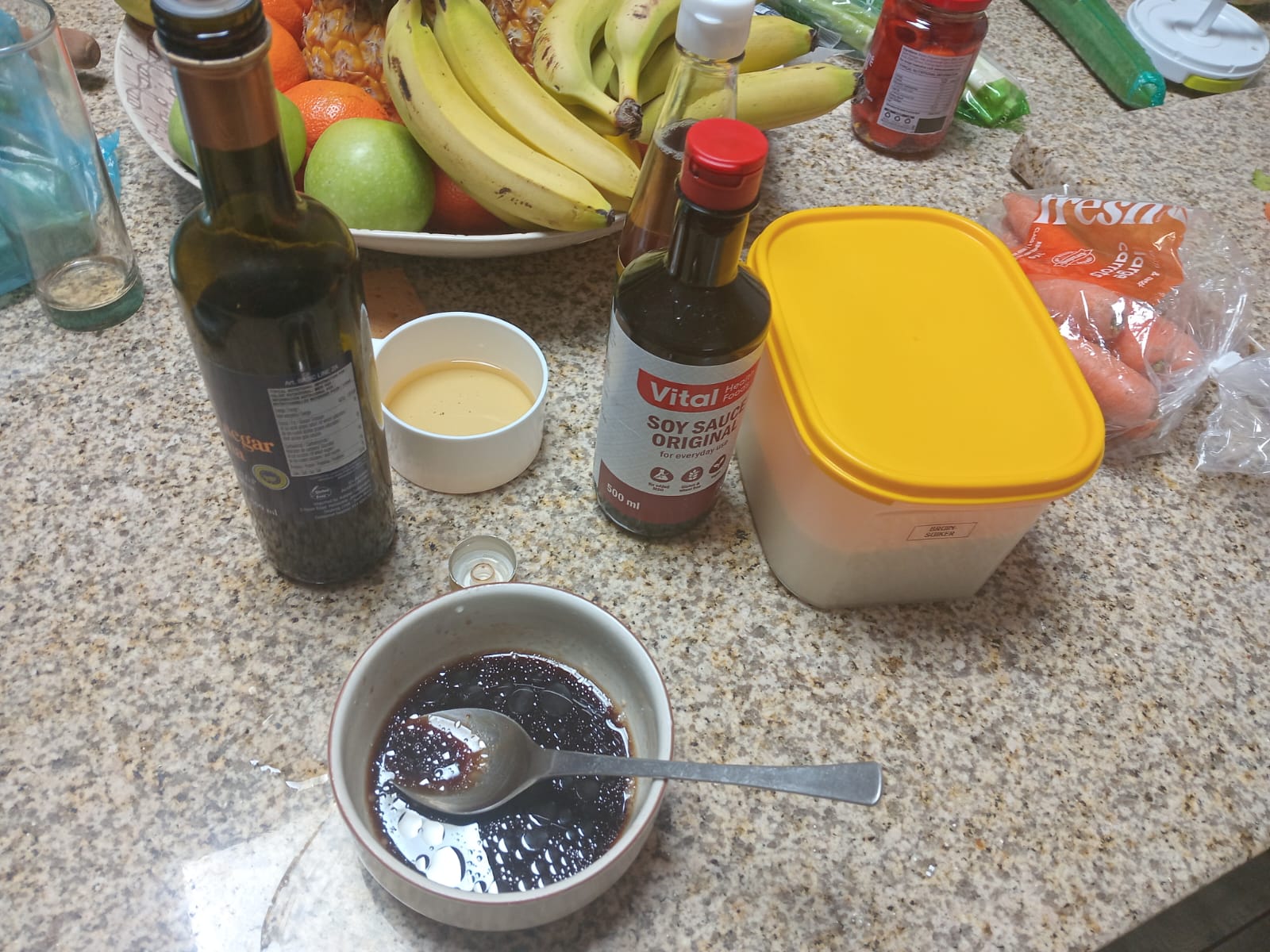 the dark sauce stirred in a small bowl, balsamic and soy bottles behind