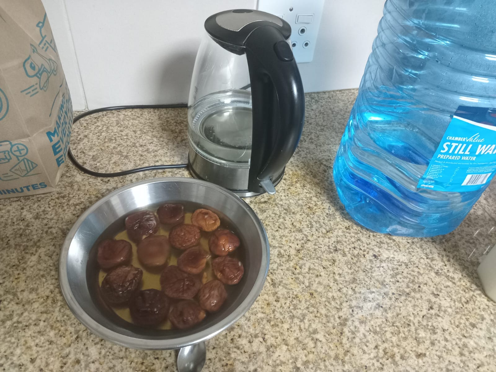 dried shiitake soaking in a steel bowl beside the kettle