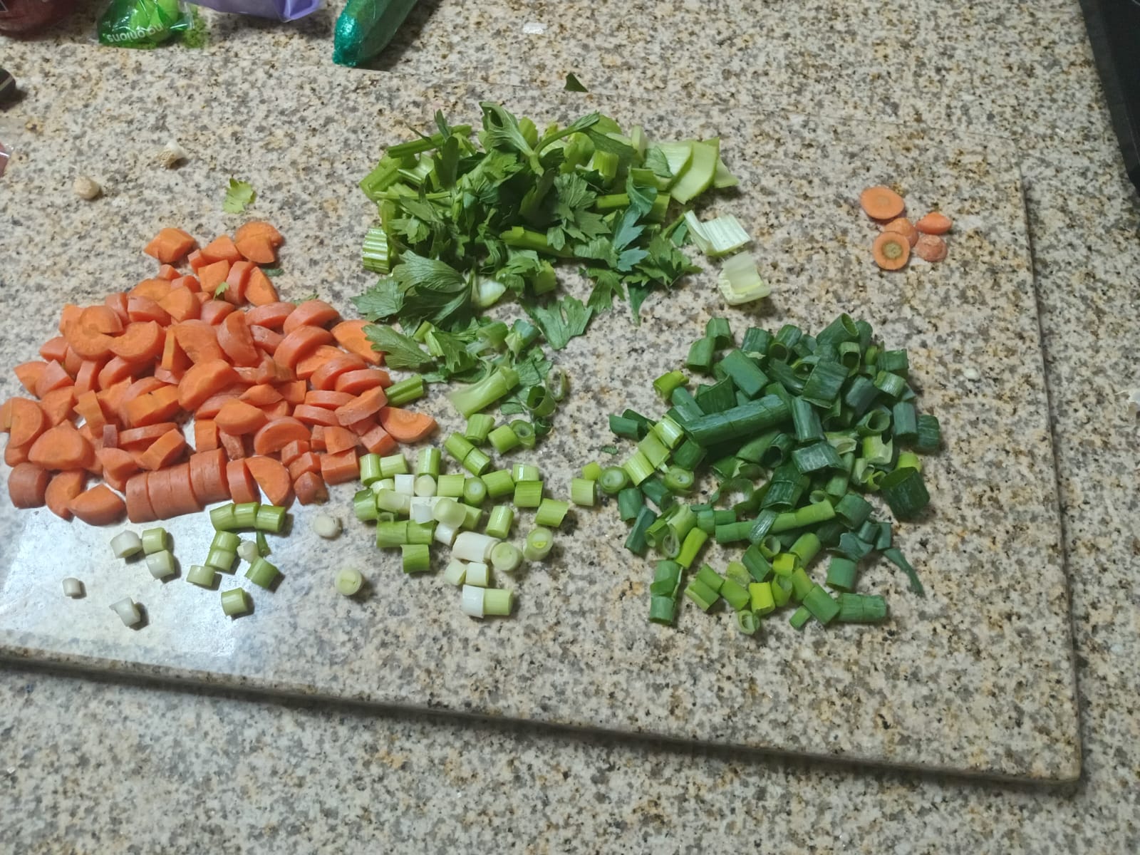 carrot slices, diced celery, and spring onion whites and greens in separate piles