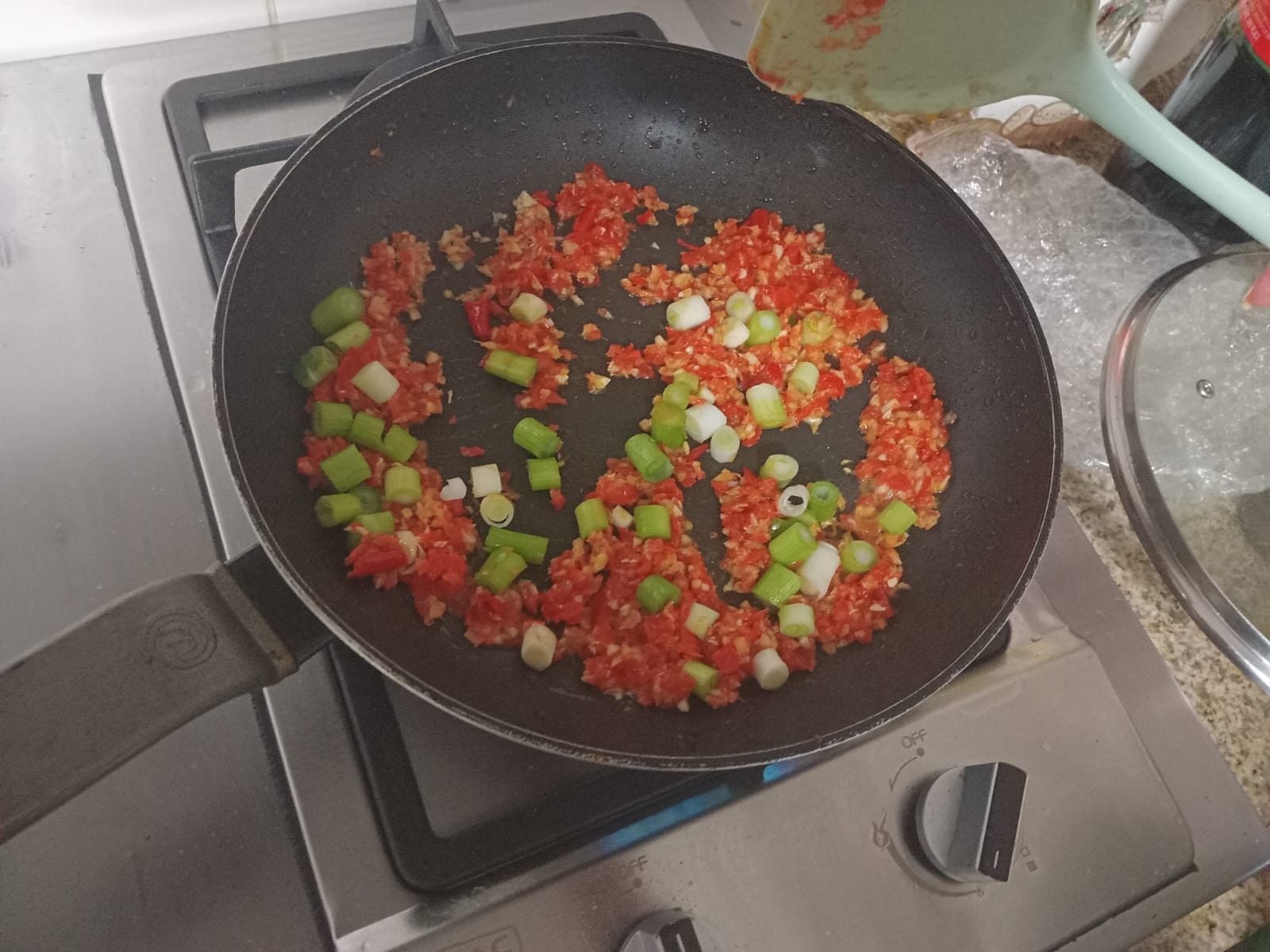 chopped red Peppadew and spring onion whites frying in the wok